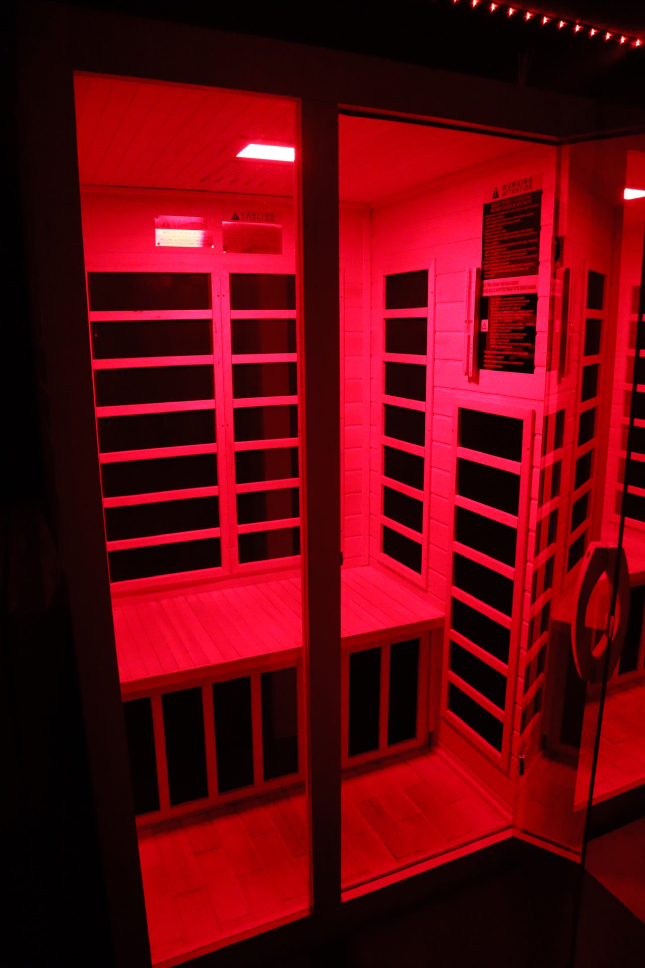 Dark cedar sauna illuminated with red and amber light